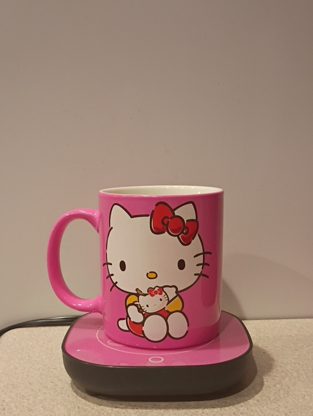 Hello Kitty themed ceramic mug and electric warmer set features a bright Pink
